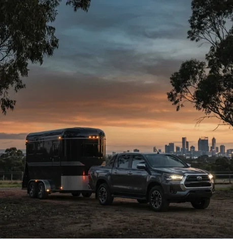 Professional Removal — Toyota HiLux towing enclosed equine trailer at dusk
